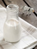 20314093-milkin-bottle-with-cow-on-background-healthy-food-selective-focus